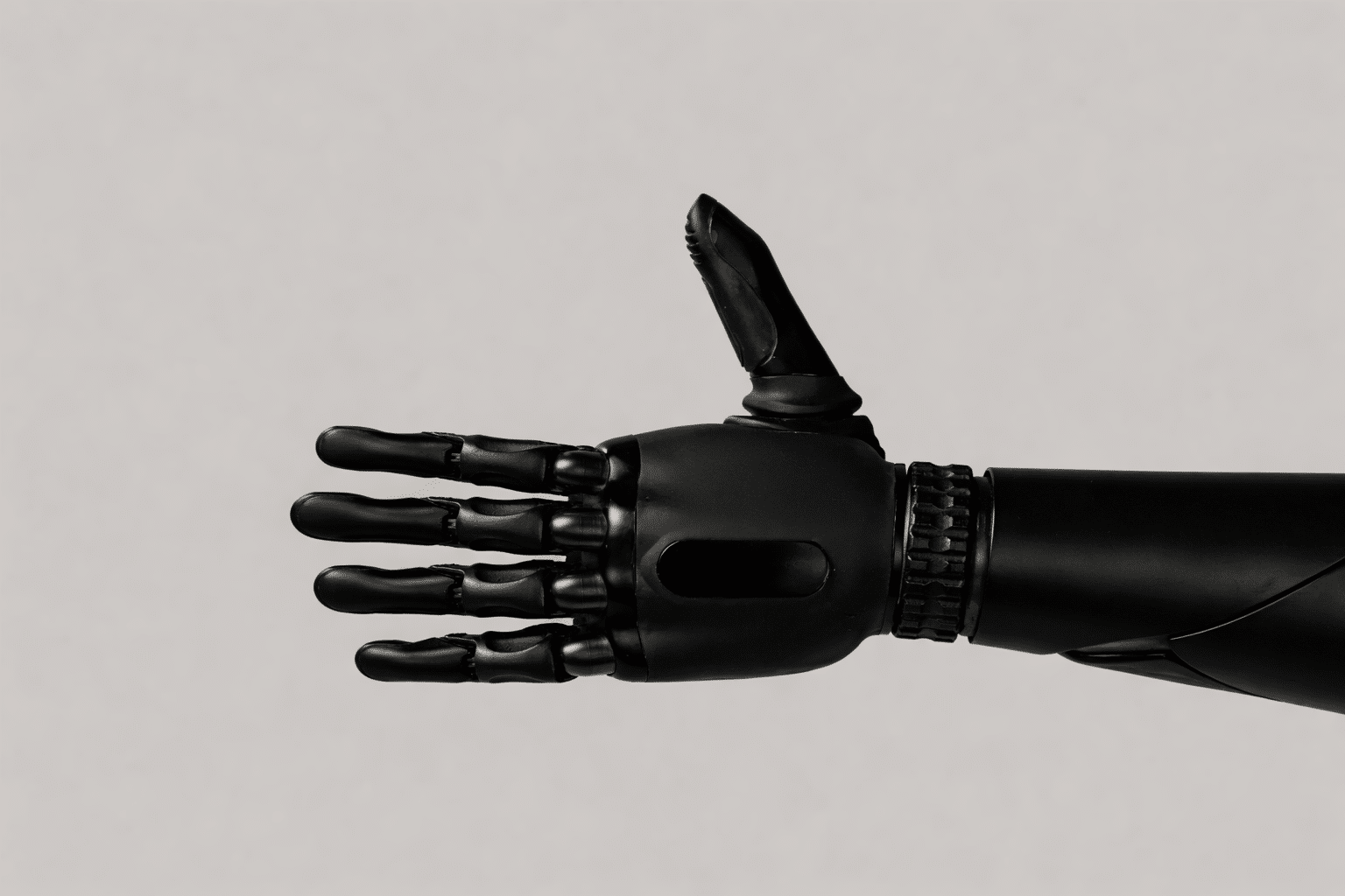 Main robotique noire avec doigts articulés métalliques sur fond clair, symbolisant la robotique avancée.