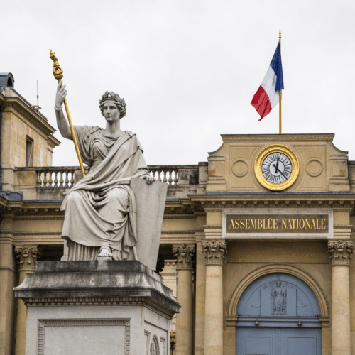 Façade de l’Assemblée nationale à Paris avec statue allégorique et drapeau français