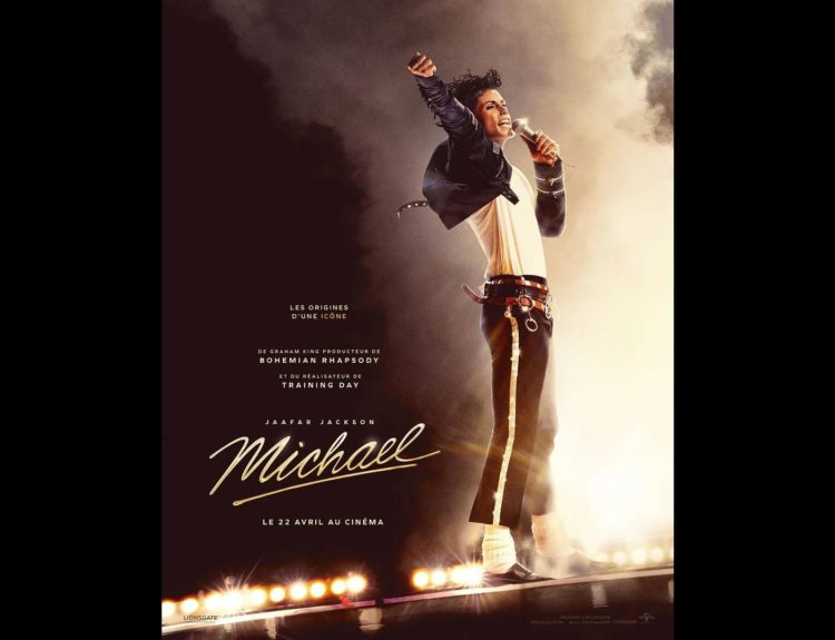 Artiste interprétant Michael Jackson chantant sur scène avec un micro, bras levé, éclairé par des projecteurs